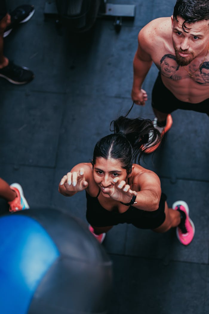 Energetic individuals participating in an indoor gym workout session, focusing on fitness and strength training.